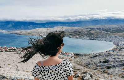 Rear view of woman looking at sea shore against sky