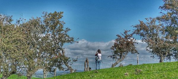 Man and woman on field against sky