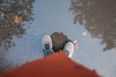 Low section of man standing on puddle