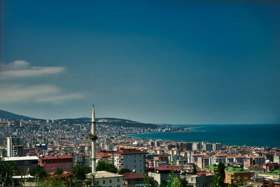 High angle view of townscape by sea against sky