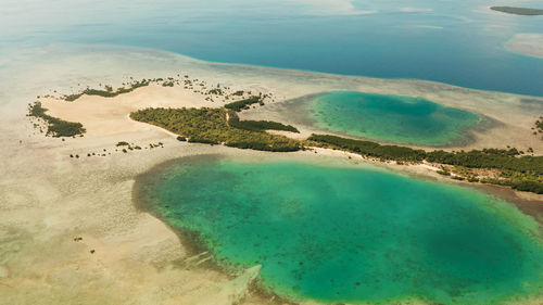 Honda bay with tropical islands and sandy beaches surrounded by coral reef with azure water.