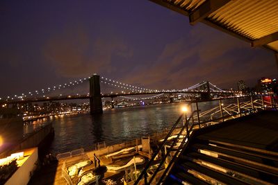 View of bridge over river at night