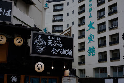 Low angle view of road sign against buildings in city