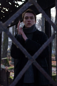 Portrait of beautiful man seen through fence