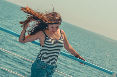 Full length of woman standing by sea