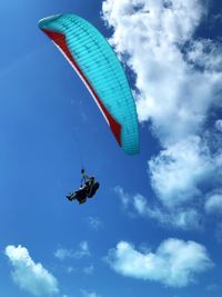 Low angle view of person paragliding against sky