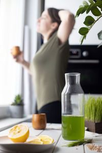 Wheat grass juice bottle on table at home