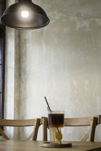 Electric lamp on table against wall at home