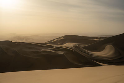 Scenic view of desert against sky during sunset