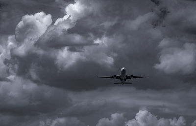 Airplane flying on dark sky and white fluffy cloud. commercial airline with dream destinations.