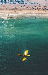 Airplane flying over landscape against blue sky