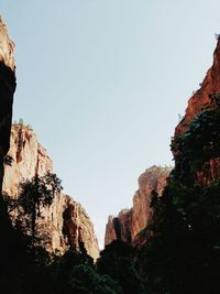 Low angle view of cliff against clear sky