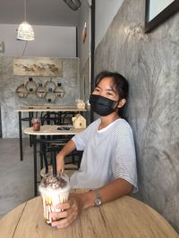 Man holding ice cream on table at home