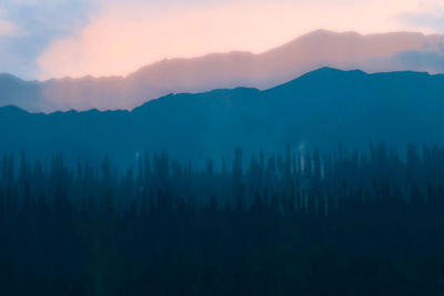 Scenic view of silhouette mountains against sky at sunset