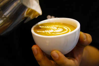 Close-up of hand holding coffee cup