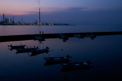 Boats moored in sea at sunset