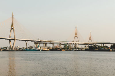 View of suspension bridge over river against clear sky