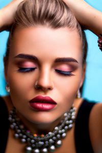 Close-up of young woman with eyes closed in make-up