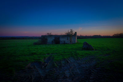 House on field against sky during sunset