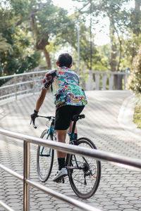 Rear view of man riding bicycle on street