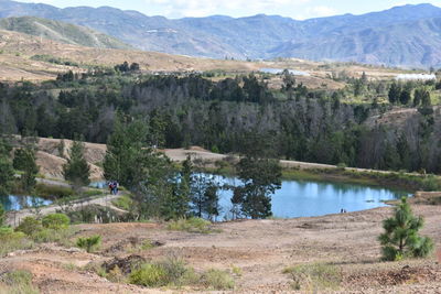 Scenic view of river by mountains against sky