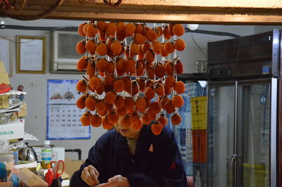 Woman by dried persimmons in store