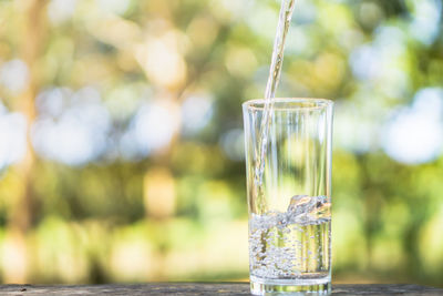 Closeup pouring fresh water on drinking glass