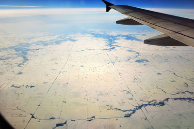 Cropped image of airplane wing over landscape
