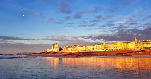 Scenic view of city by sea against sky