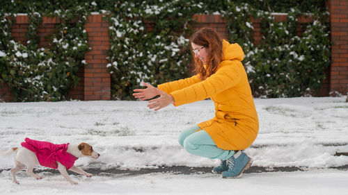 Portrait of young woman standing on snow covered field