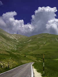 Rear view of man walking on road against sky