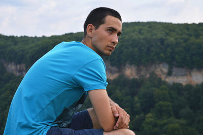 Side view of thoughtful man against rocky mountain