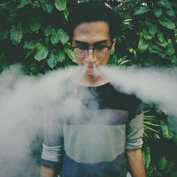 Portrait of young man smoking outdoors