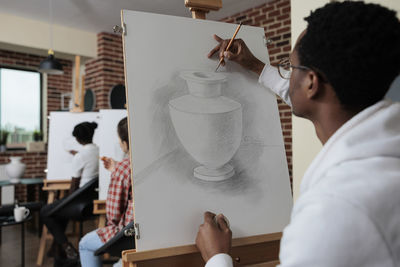 Side view of woman holding drink at restaurant