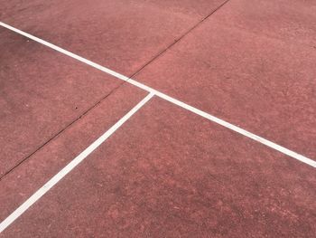 High angle view of white lines on red tennis court