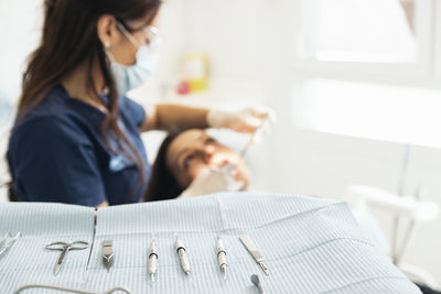 Female dentists examining woman teeth at hospital