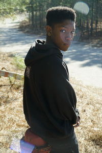 Portrait of teenage boy standing by road