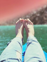 Low section of person on kayak at lake during sunny day