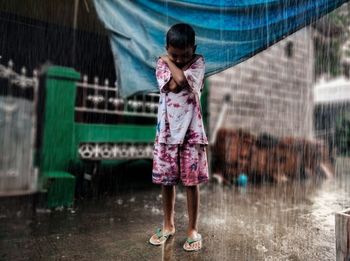 Full length of girl standing on wet rainy day