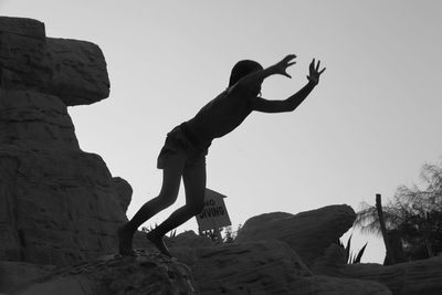 Low angle view of woman standing on rock
