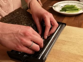 Midsection of woman using smart phone on table