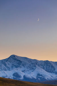 Scenic view of snowcapped mountains against sky during sunset