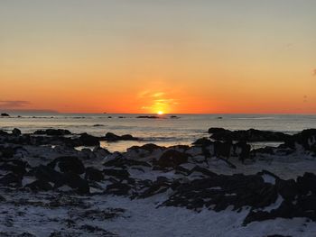 Scenic view of sea against clear sky during sunset