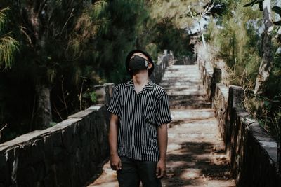 Rear view of man standing against trees