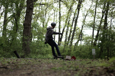 Man skateboarding on forest