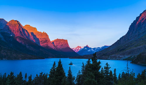 Scenic view of lake and mountains against blue sky