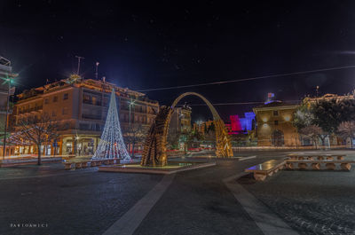 Illuminated city street and buildings at night