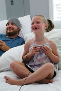 Happy girl sitting on bed