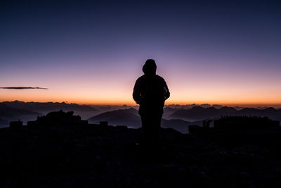 Silhouette man looking at sunset