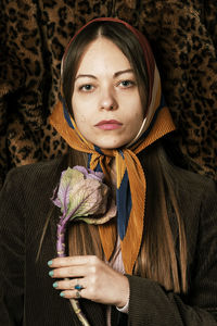 Portrait of a beautiful young woman holding flower